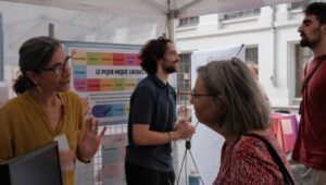Une animatrice échange avec une visiteuse devant le plateau géant du Pique-nique linguistique.