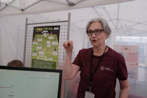 Ioana Chitoran s’adresse au public à côté d’un écran affichant un quiz sur les langues, devant l’affiche « Le français va très bien, merci ».