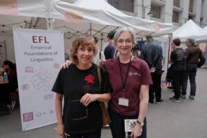 Deux membres de l’équipe posent devant le kakémono EFL, au milieu des stands de la Fête de la Science.